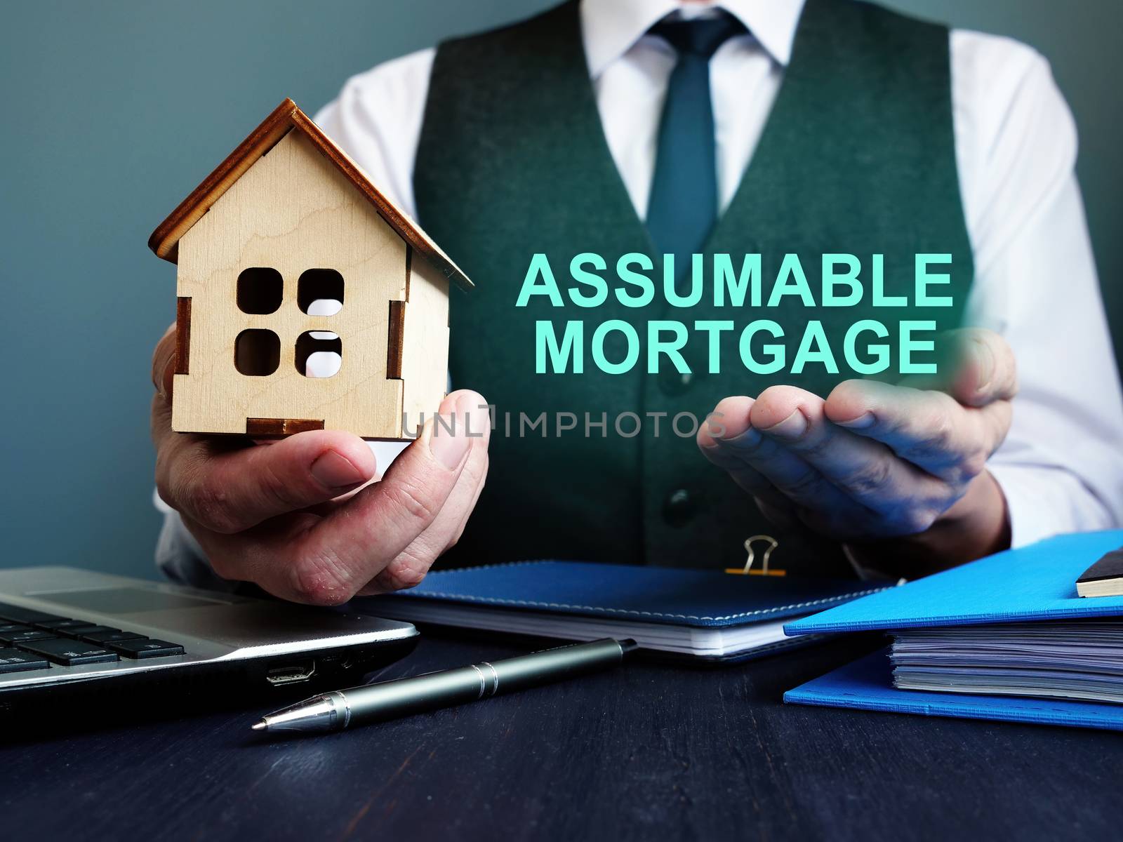 Realtor with model of home and sign Assumable mortgage.