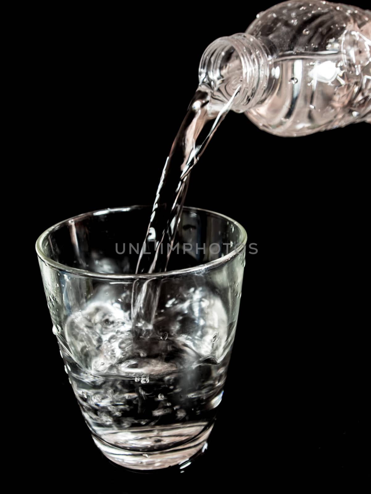 Pour water from the bottle into the glass