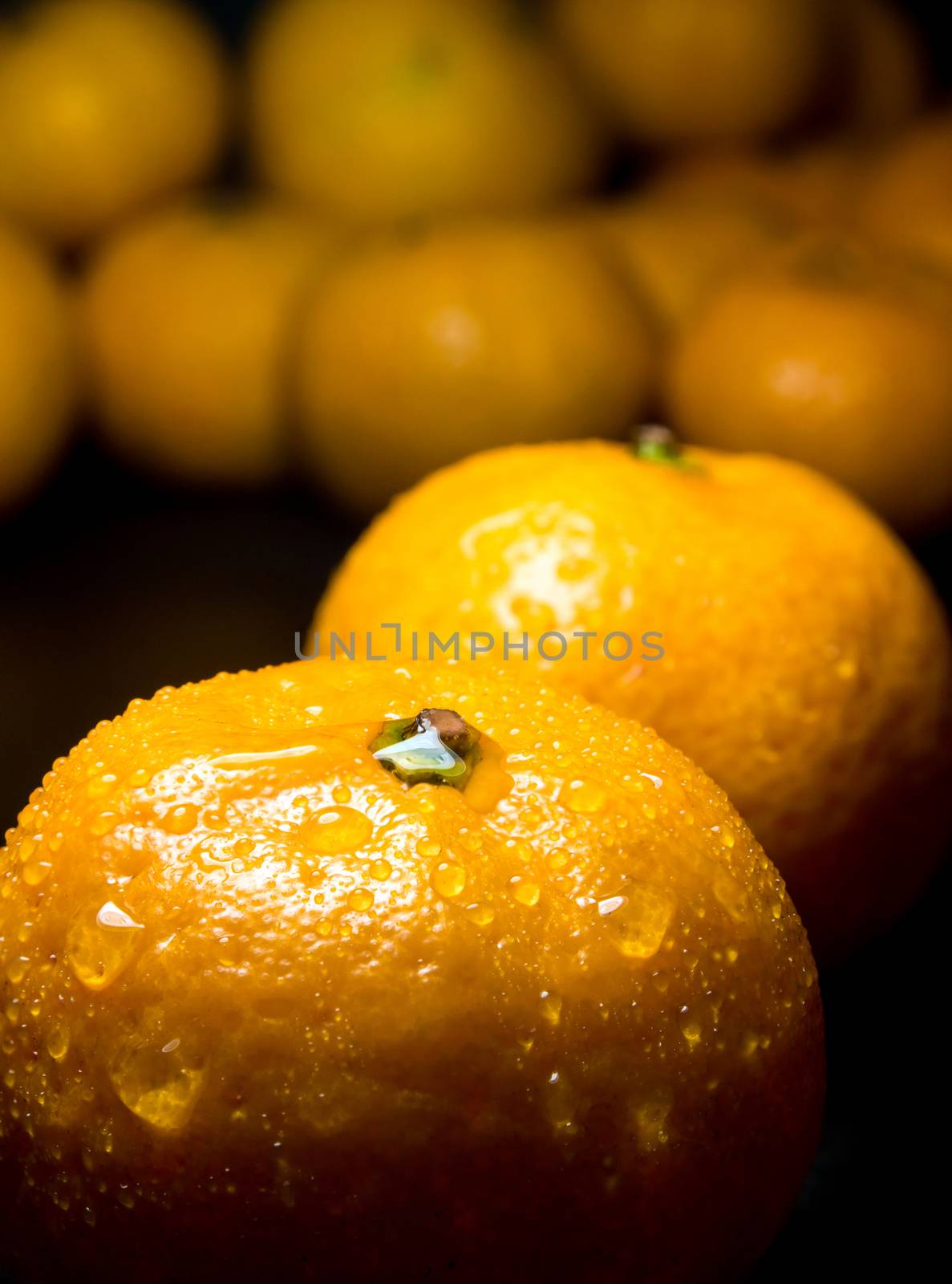 Close-up of Water droplet on glossy surface of freshness orange on black background