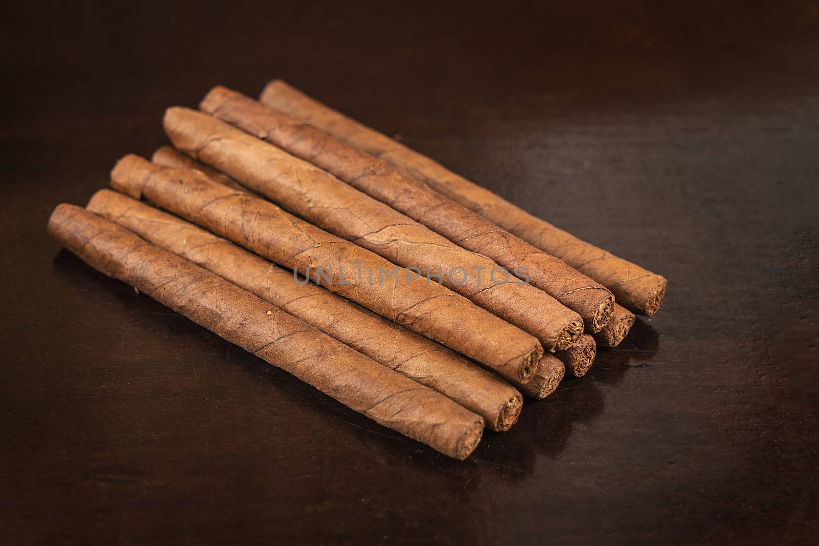 A group of nine small cigars on a table