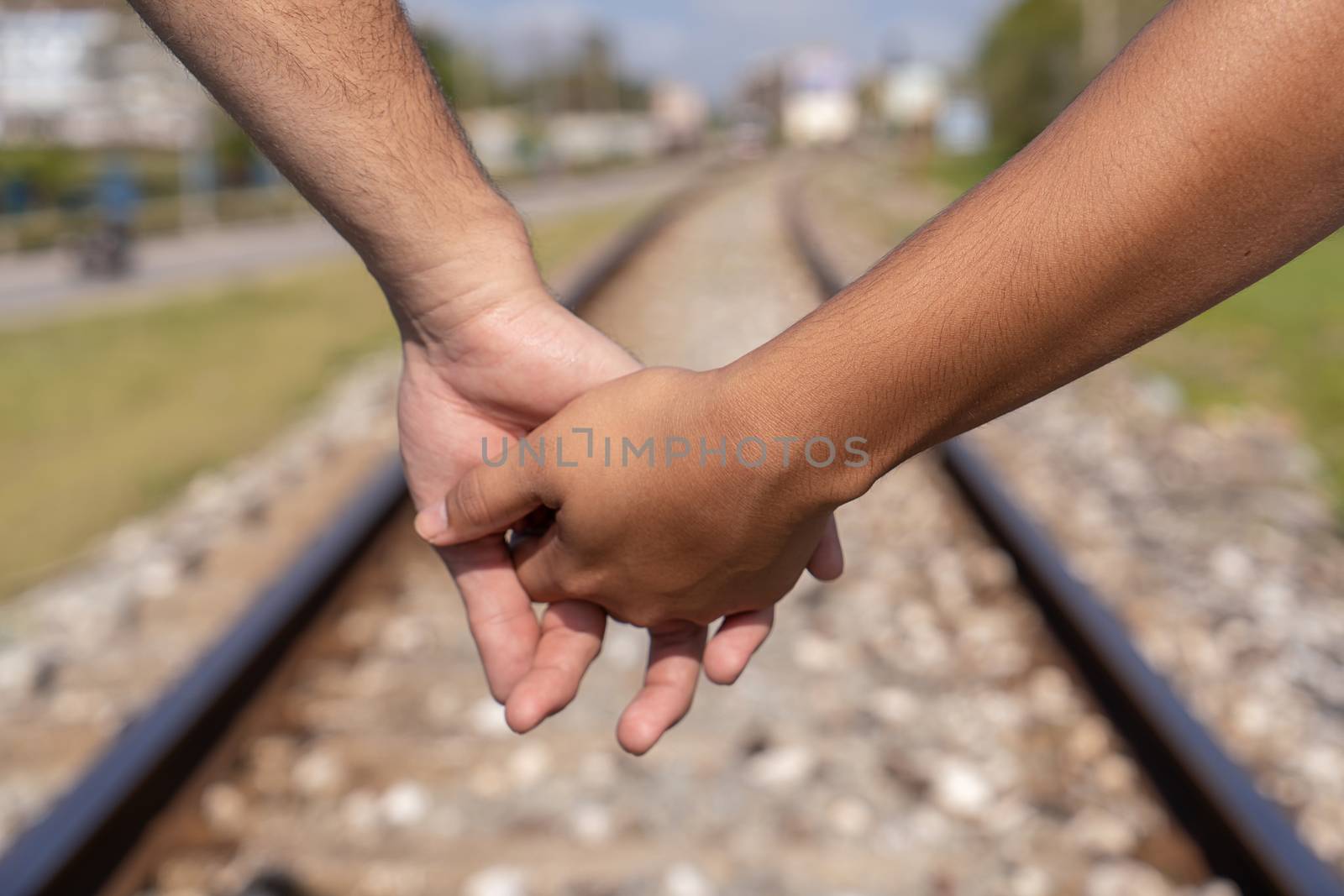 Given hands of two people on the train line