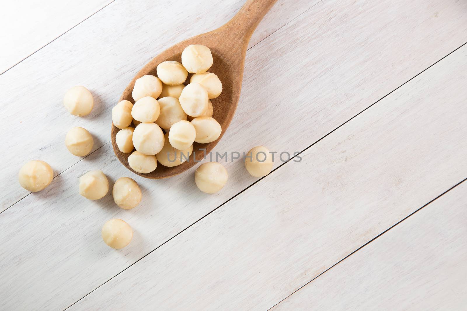 macadamia nuts in wooden spoon