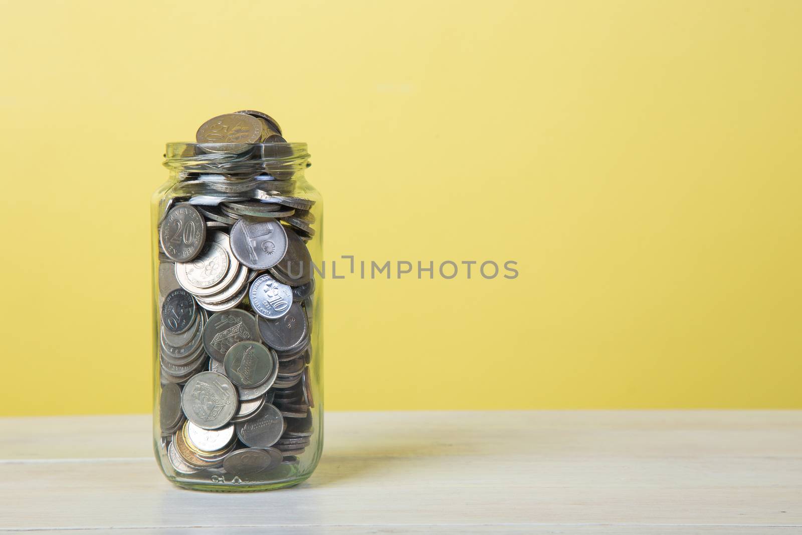 Jar for savings full of coins.