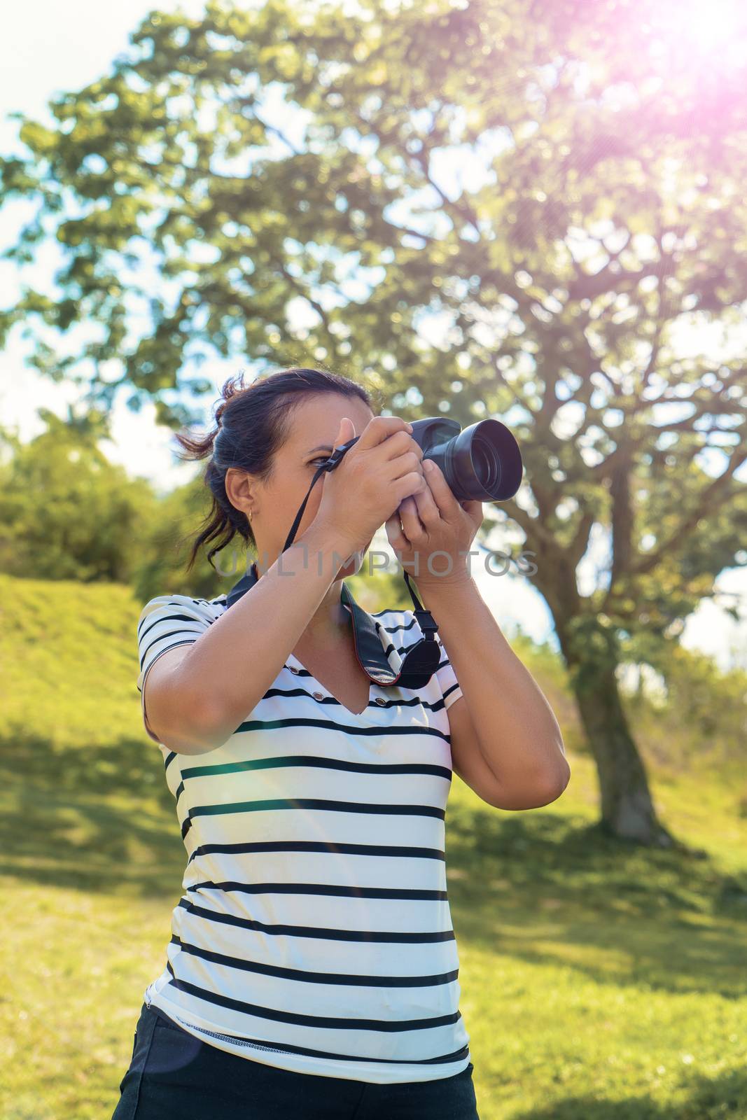 A black hair standing woman with a camera taking pictures