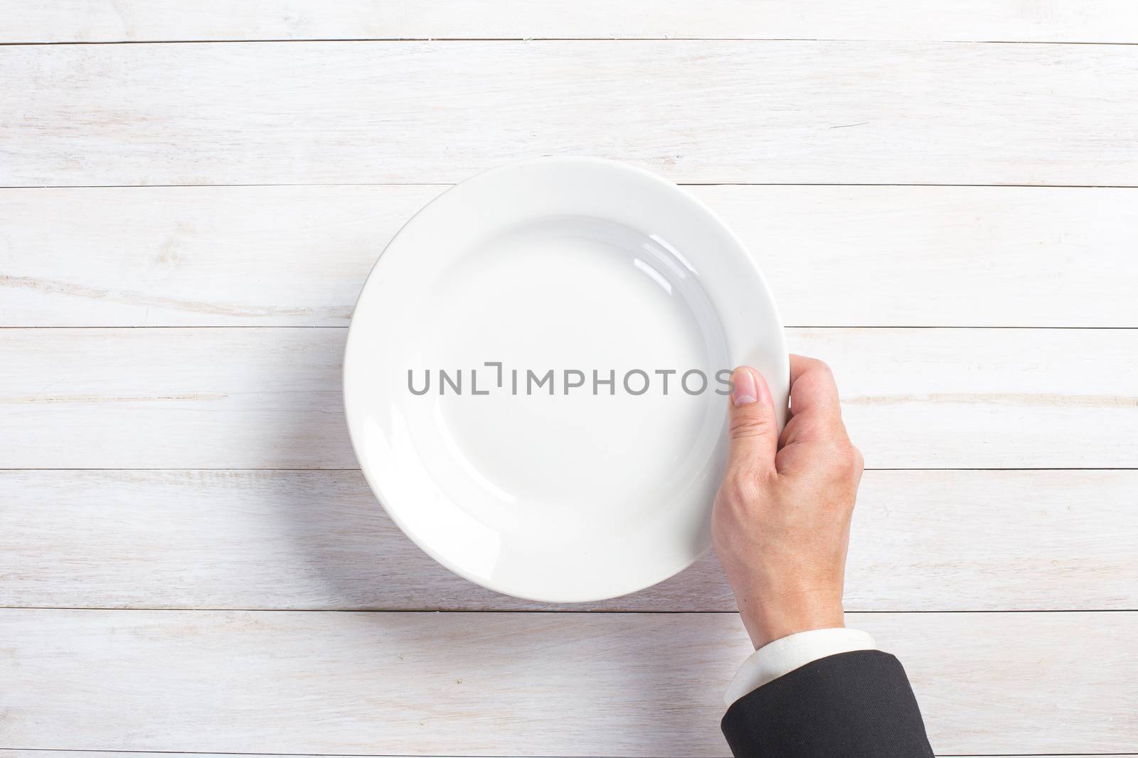 man's hand holding a white empty plate by tehcheesiong