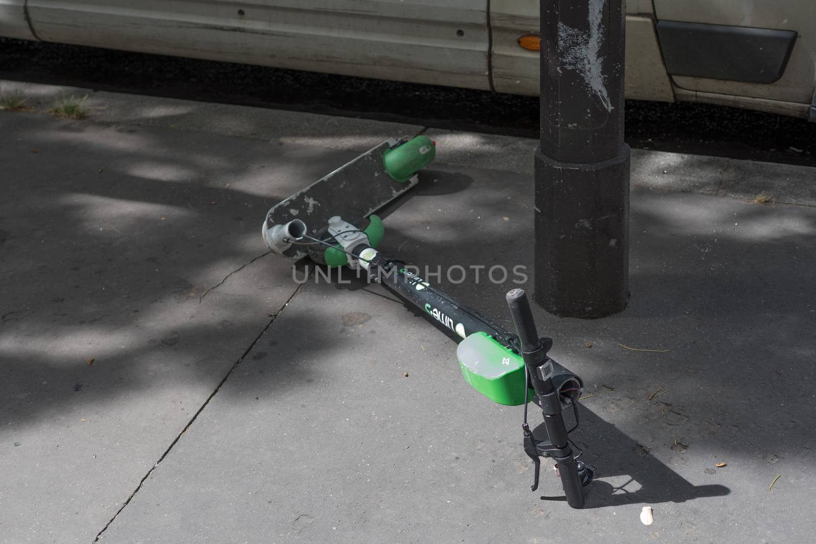 French parisian non ecological lifestyle : short term use objects : Broken electric scooter on the road in Paris, France by ontheroadagain