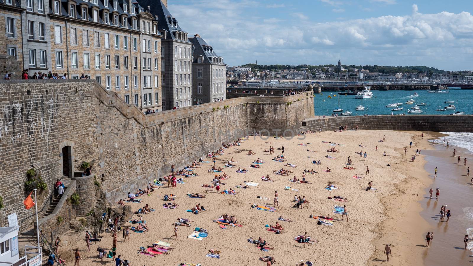 Beautiful beach of saint Malo, France 17-9-19. Green sea, blue sky with people swimming and boats in background