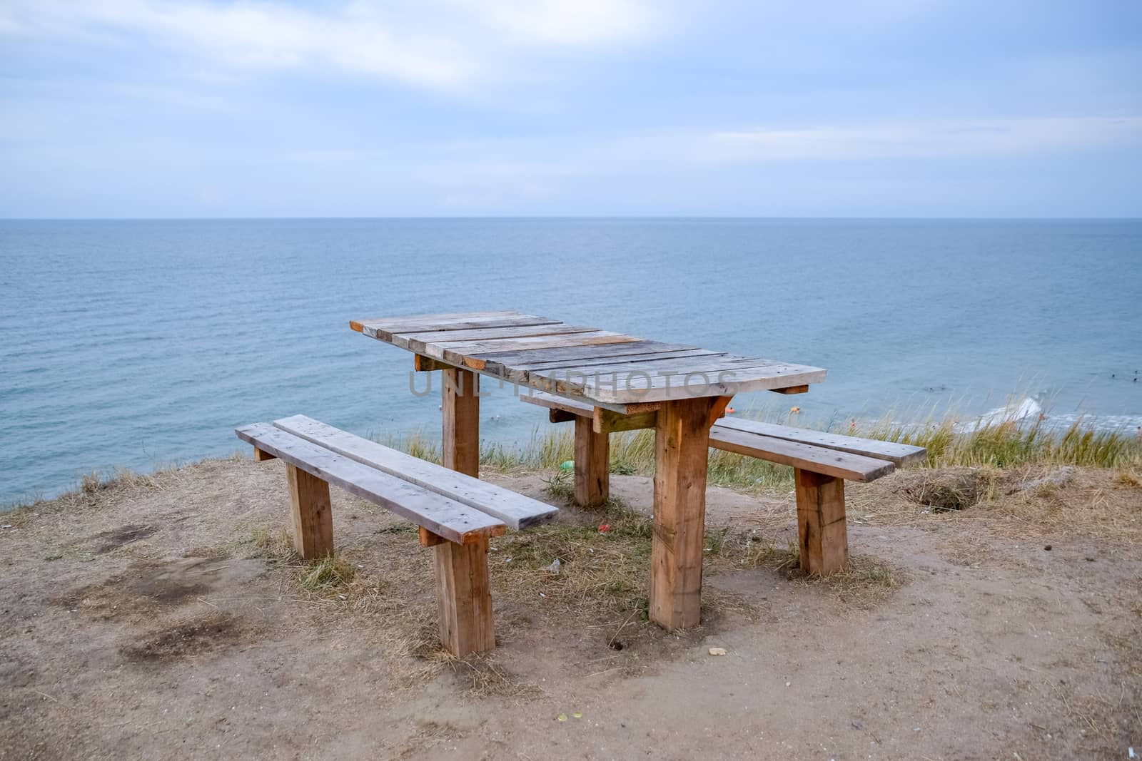 A table and benches by the sea. A place to sit and relax.