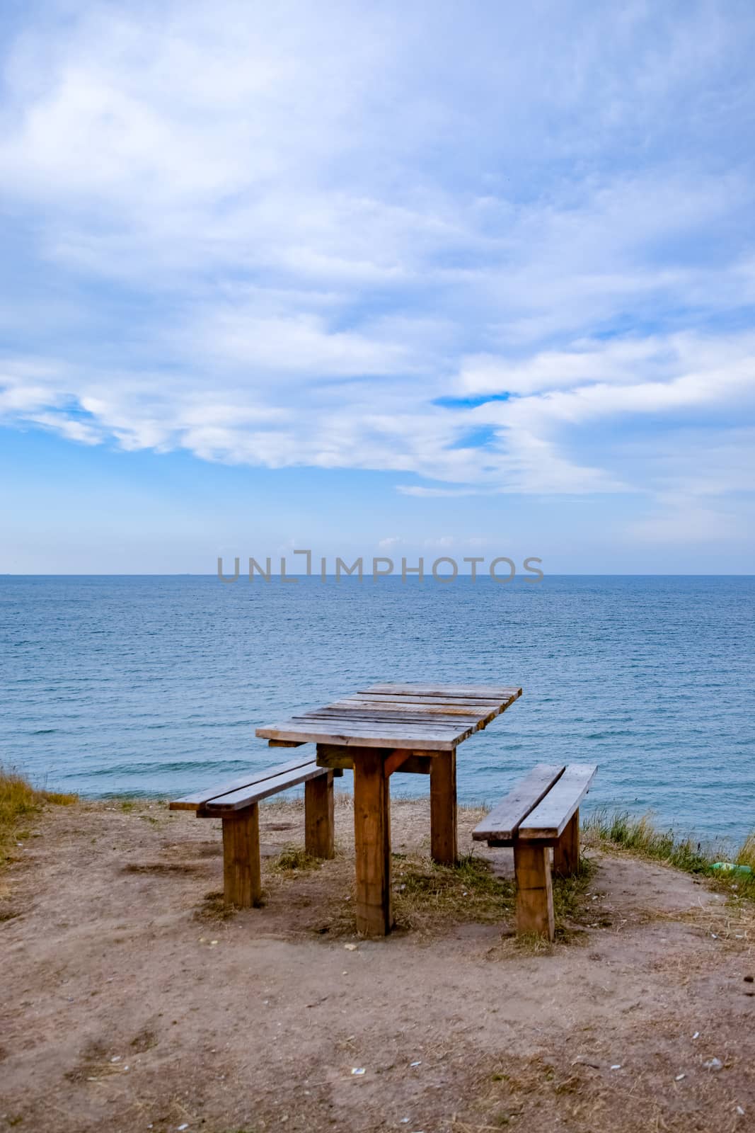 A table and benches by the sea. A place to sit and relax.