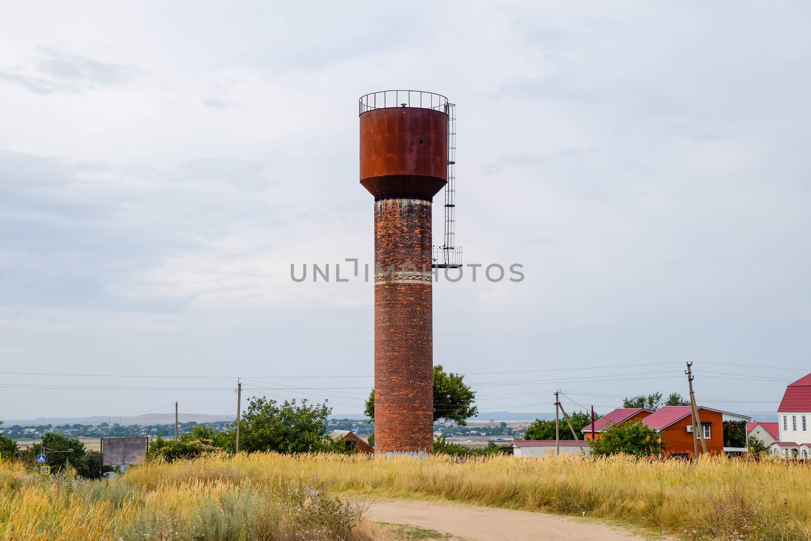 Rusty water tower against the sky. Old water pump.