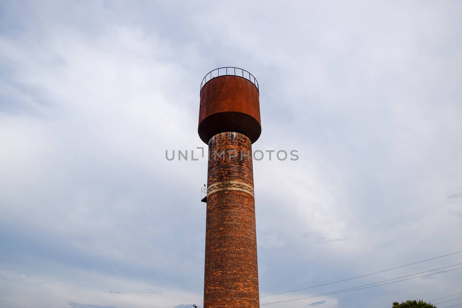 Rusty water tower against the sky. Old water pump.