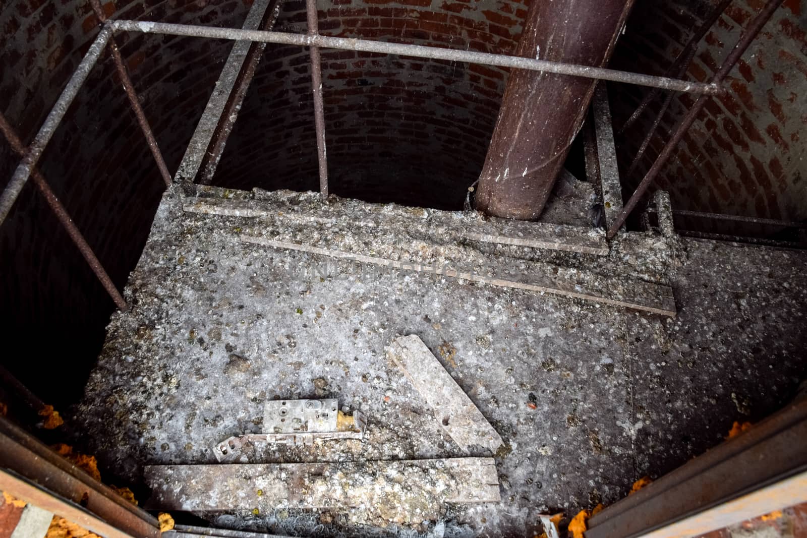 Rusty water tower inside view from top to bottom. Old water pump. Ladder to the water tank, pigeon droppings.