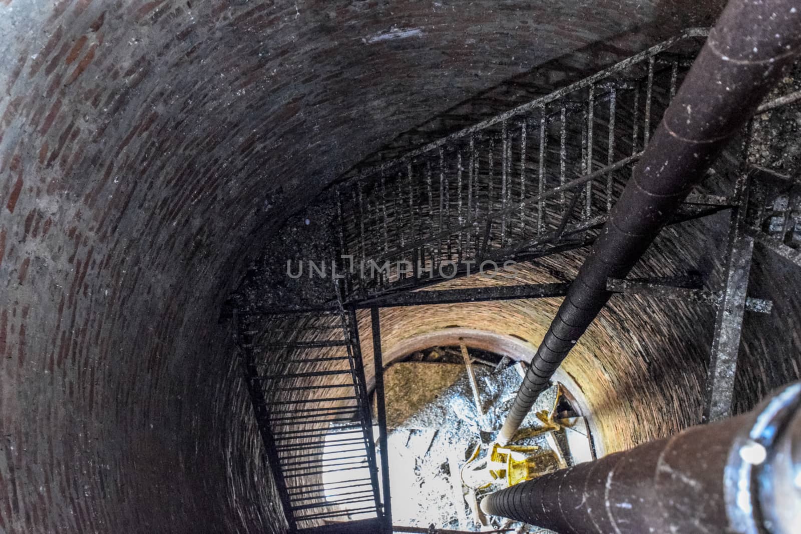 Rusty water tower inside view from top to bottom. Old water pump. Ladder to the water tank, pigeon droppings.