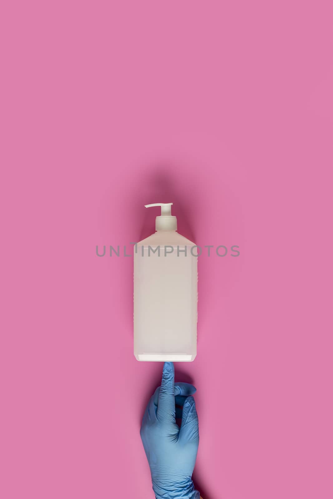 Doctor holds sanitizer gel in hands blue medical gloves on pink  by ArtSvitlyna