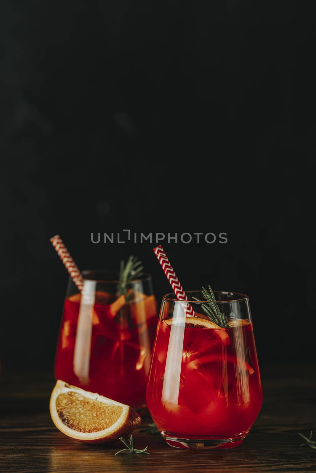 Two glasses of campari gin spritz. Cocktail of sweet, a touch of bitter from the campari and gorgeous fizz from the champagne topper. Dark background