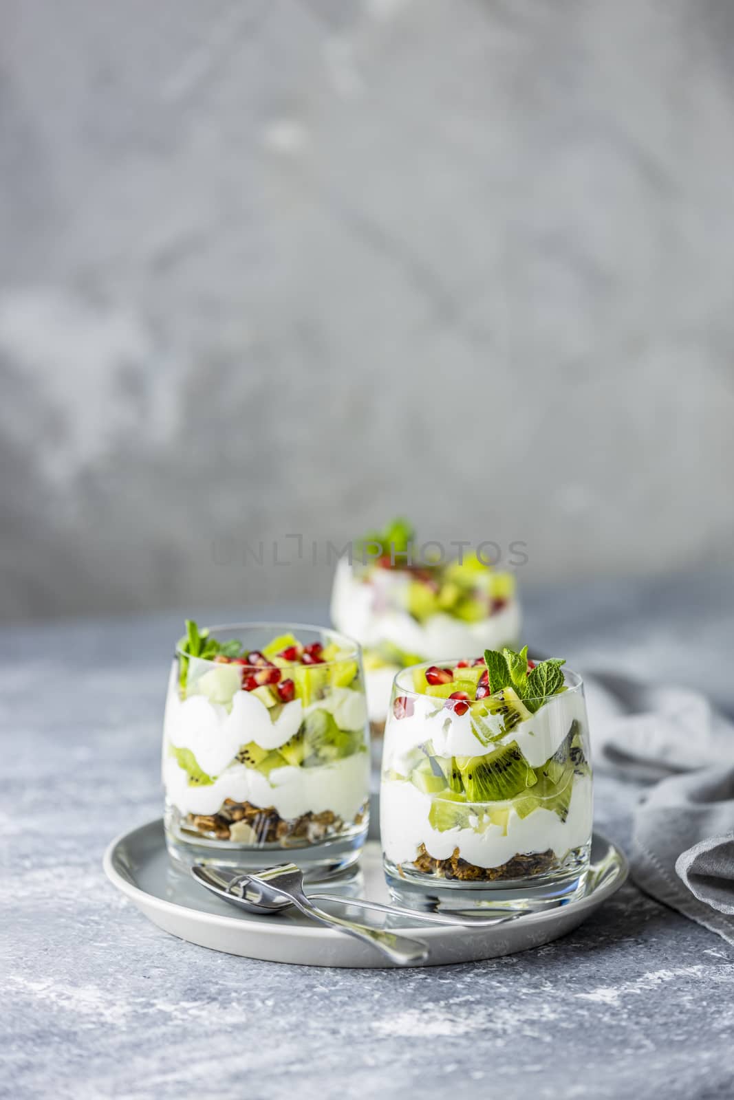 Homemade yogurt parfait with granola, kiwi fruit, pomegranate an by ArtSvitlyna