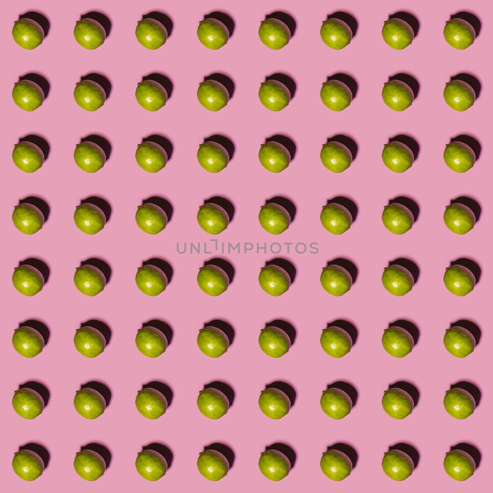 Limes pattern on pink background. Creative food concept. Flat lay.