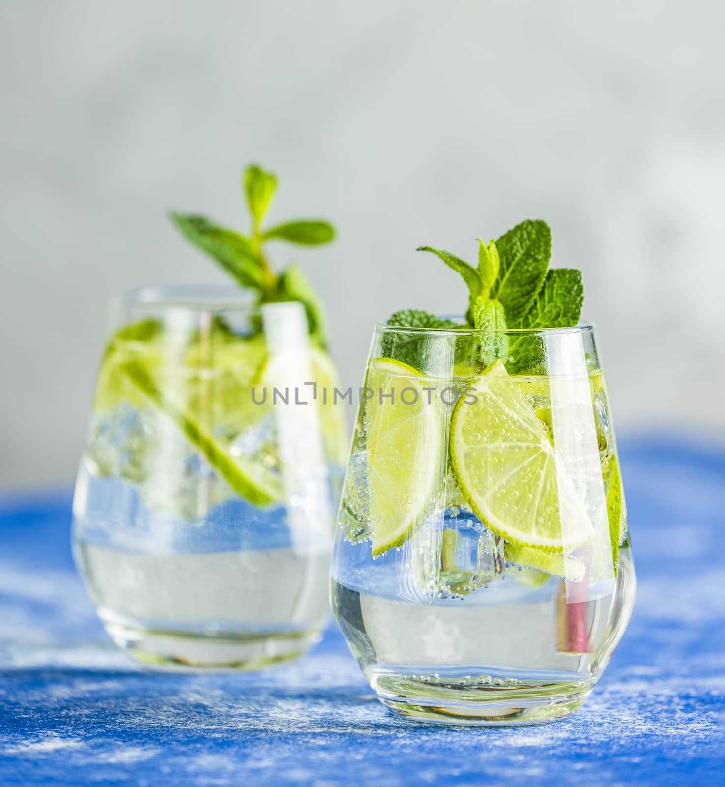 Two detox water or mojito. Summer bright drinks with mint. Refreshing drinks and juices from juicy fruits and mint. A new kind of mojito with kiwi, lime and mint and of course ice.