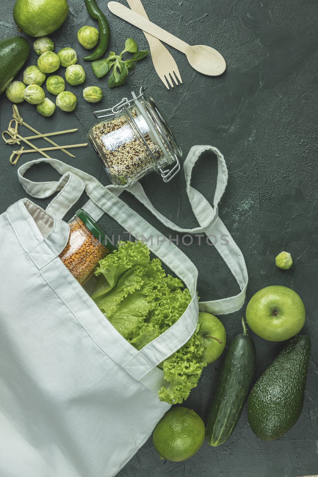 Zero waste concept. Eco-friendly shopping, flat lay. Fresh organic green vegetables and fruits on green background. Spring diet, healthy raw vegetarian, vegan concept, alkaline clean eating