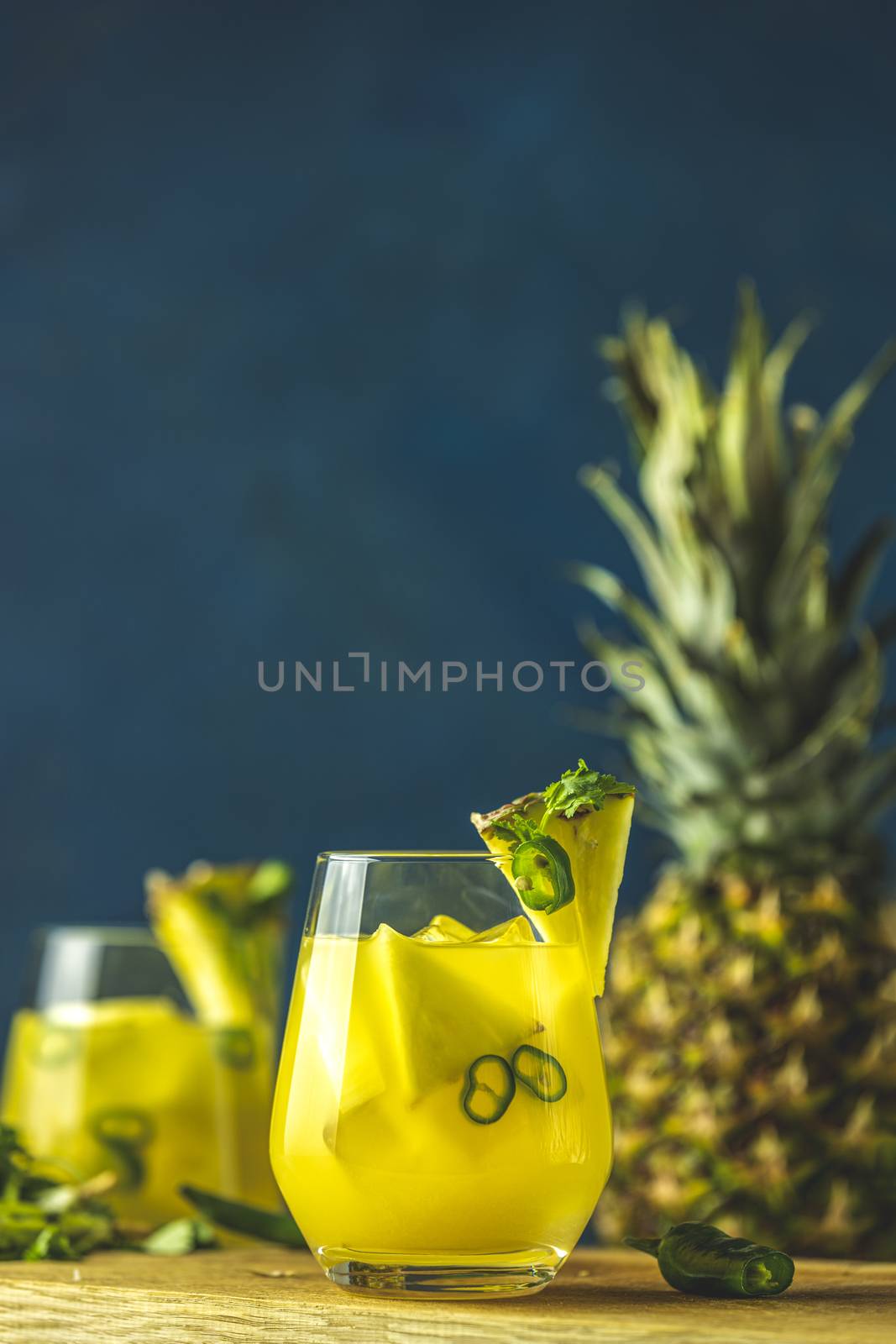 Two glasses of spicy pineapple jalapeno mezcalita or margarita for Cinco de Mayo is a refreshing cocktail made with pineapple, cilantro, jalapeno and mexican distilled alcoholic beverage.