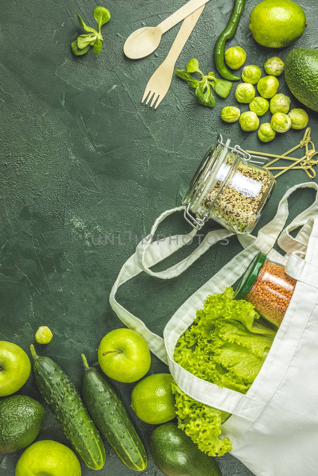 Zero waste concept. Eco-friendly shopping, flat lay. Fresh organic green vegetables and fruits on green background. Spring diet, healthy raw vegetarian, vegan concept, alkaline clean eating