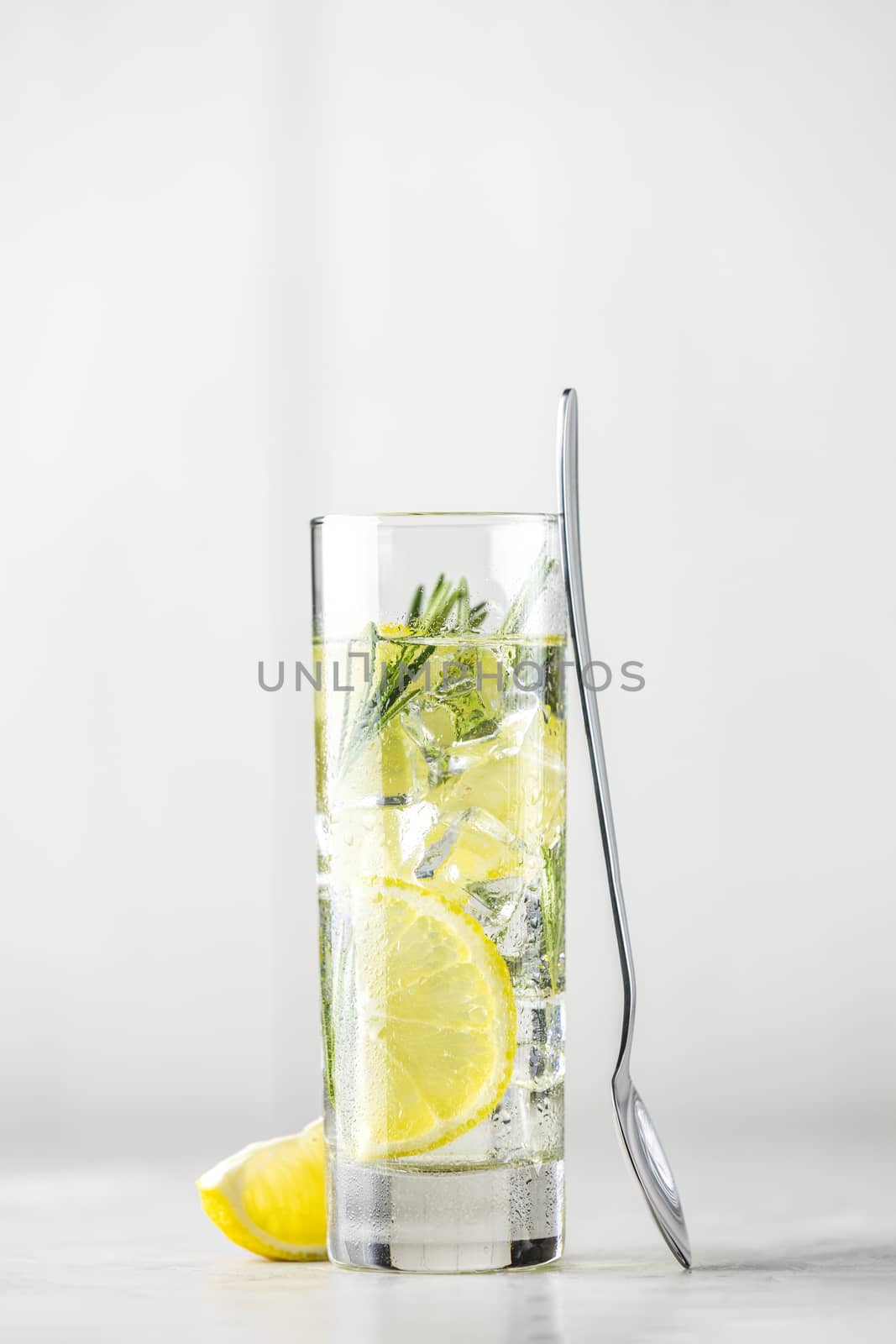 Refreshing lemon lime drink with ice cubes in glass goblets agai by ArtSvitlyna