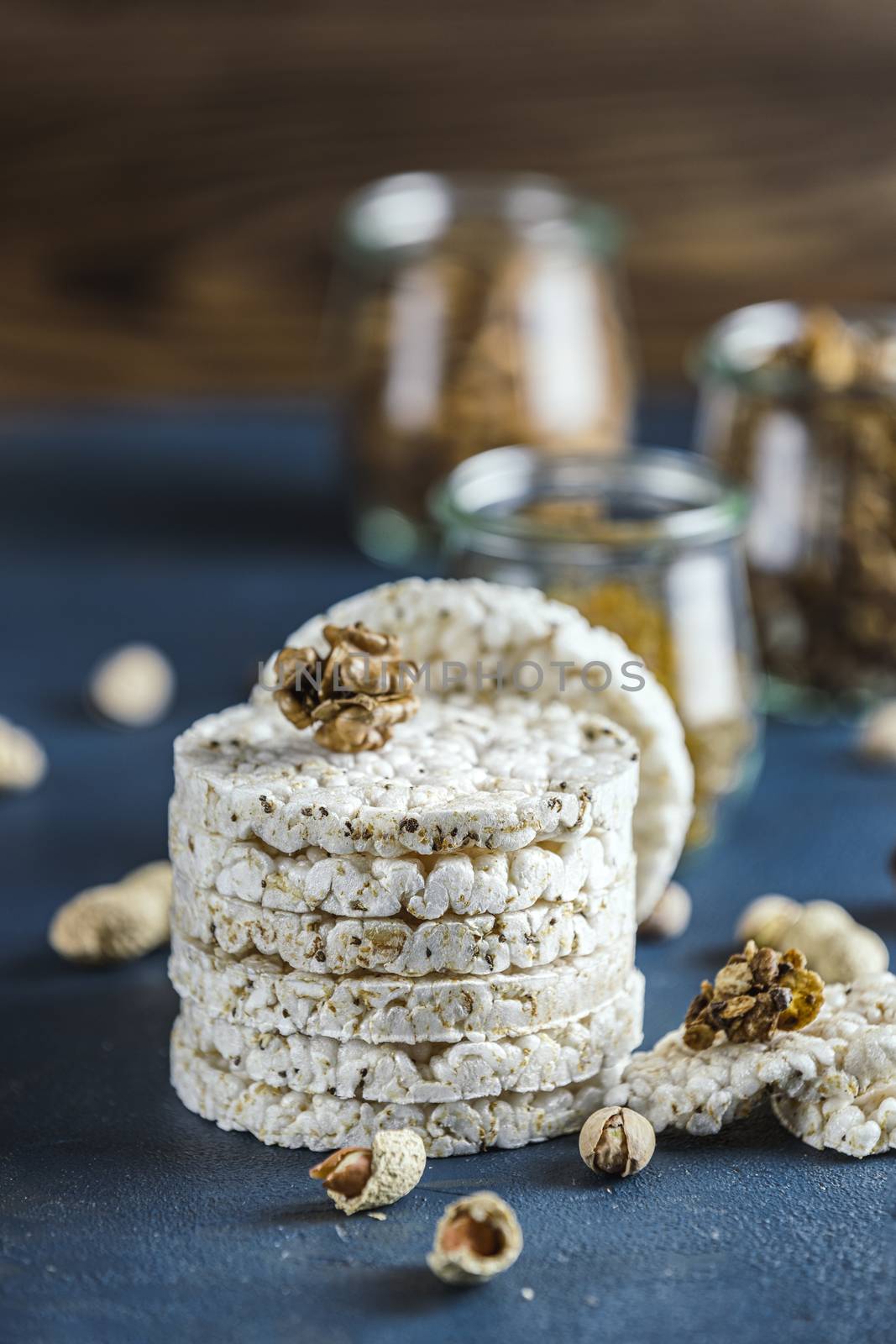 Stack of rice cakes. American puffed rice cakes. Healthy snacks with ears of wheat on classic blue concrete surface. Color of 2020 year. Classic Blue.