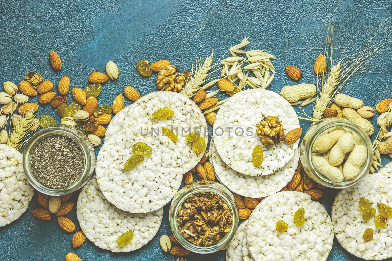 American puffed rice cakes. Healthy snacks with ears of wheat on classic blue concrete surface, top view, flat lay, copy space for you text.