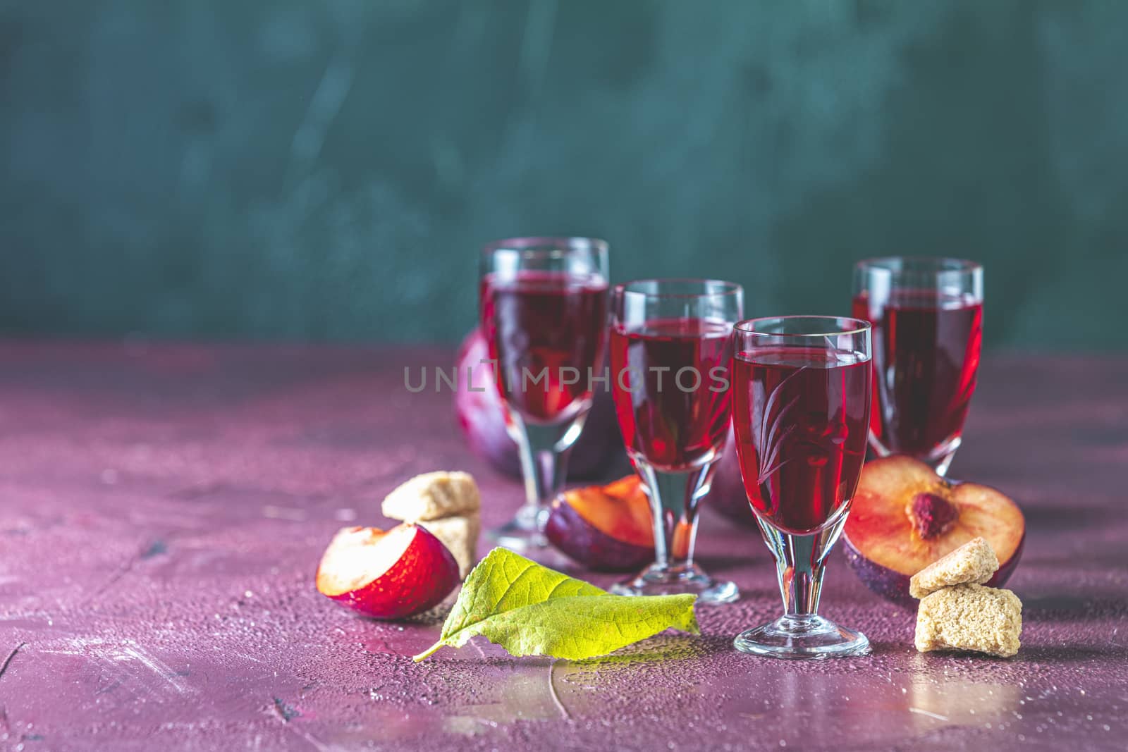 Plums strong alcoholic drink in vintage shots. Hard liquor, slivovica, plum brandy or plum vodka with ripe plums	