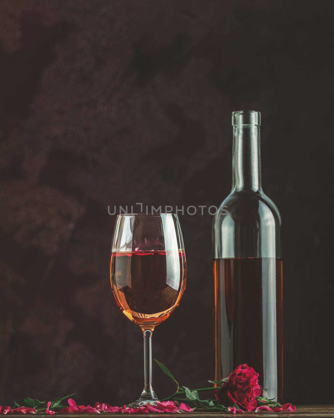 Bottle of rose wine and glass served with rose wine and rose pet by ArtSvitlyna