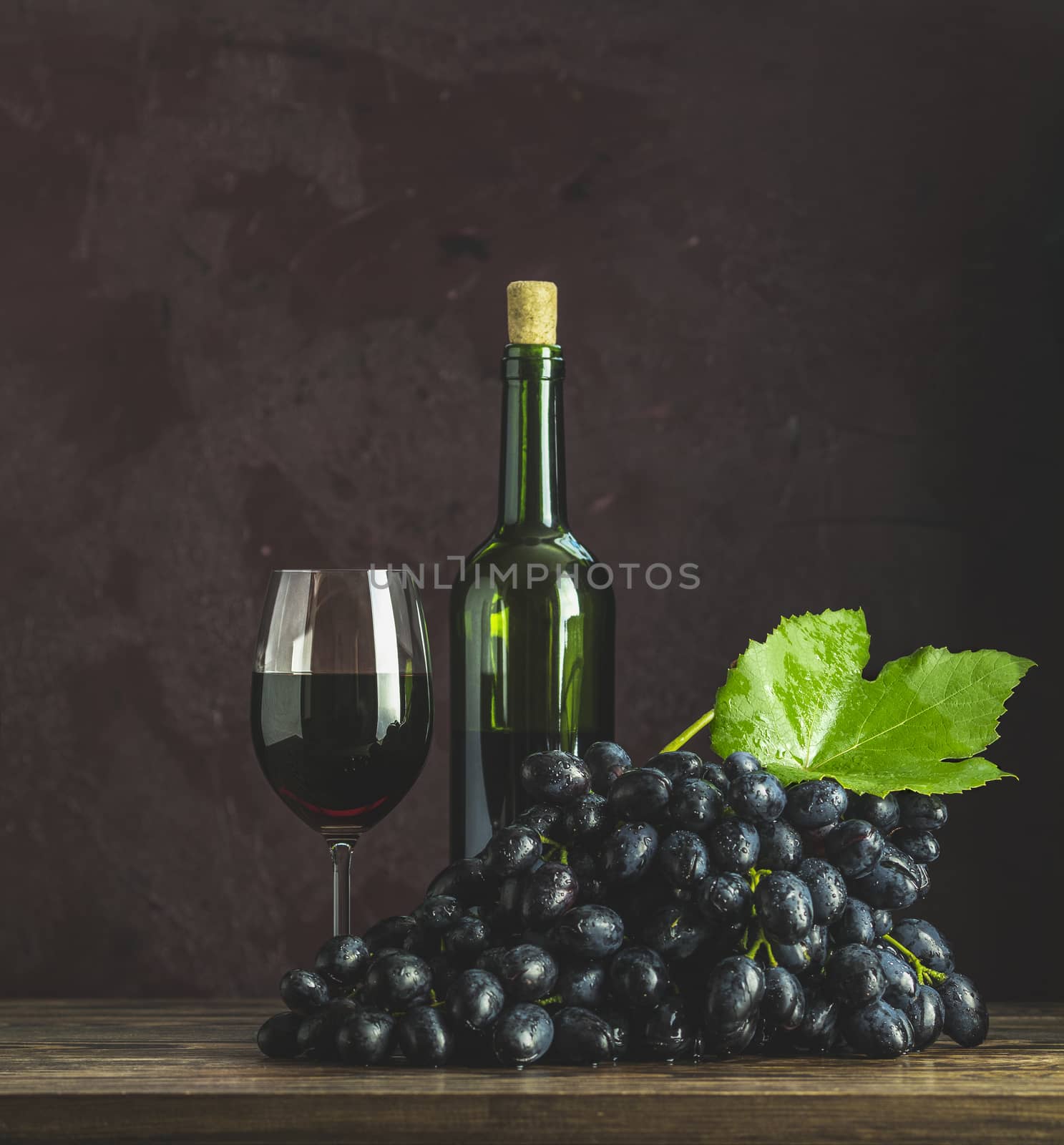 Glasses and bottles of wine and grapes on dark claret bordeaux c by ArtSvitlyna