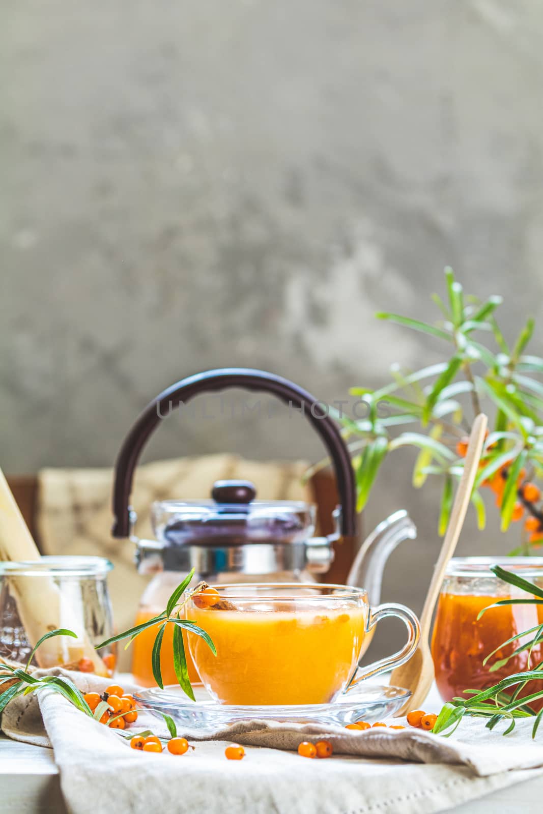 Hot spicy tea with sea buckthorn in glass cup and teapot, select by ArtSvitlyna