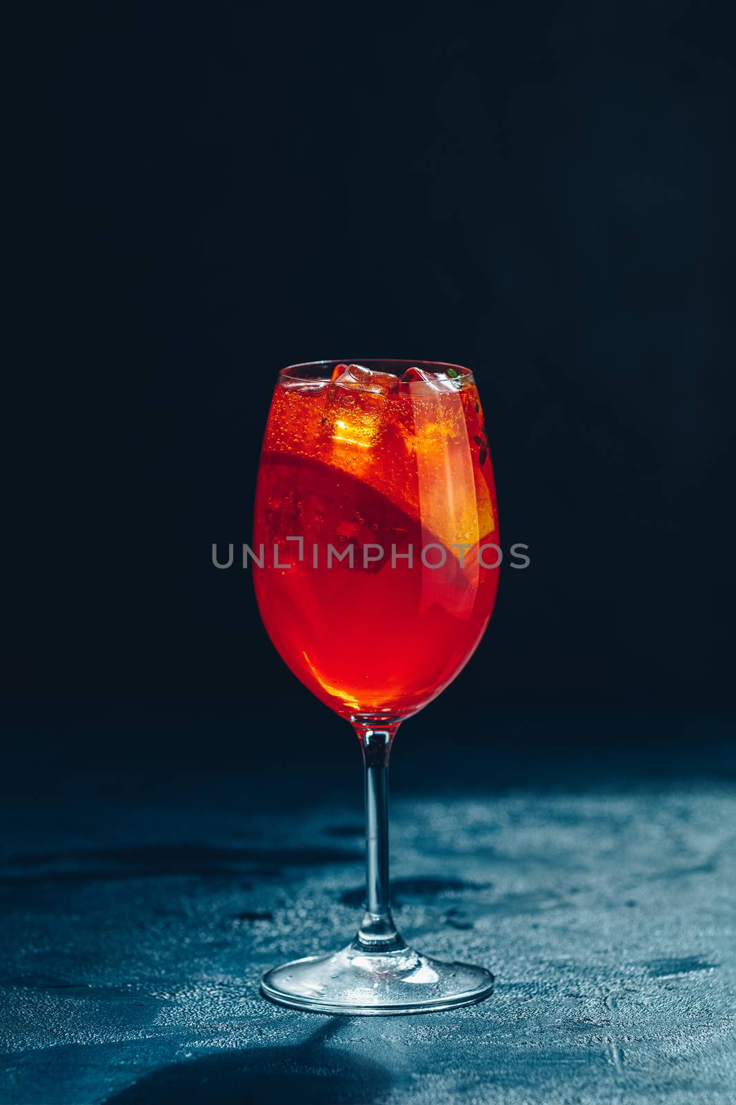 Cocktail aperol spritz on dark background.. Sunlight. Summer alcohol cocktail with orange slices. Italian cocktail aperol spritz on slate board. Trendy beverage