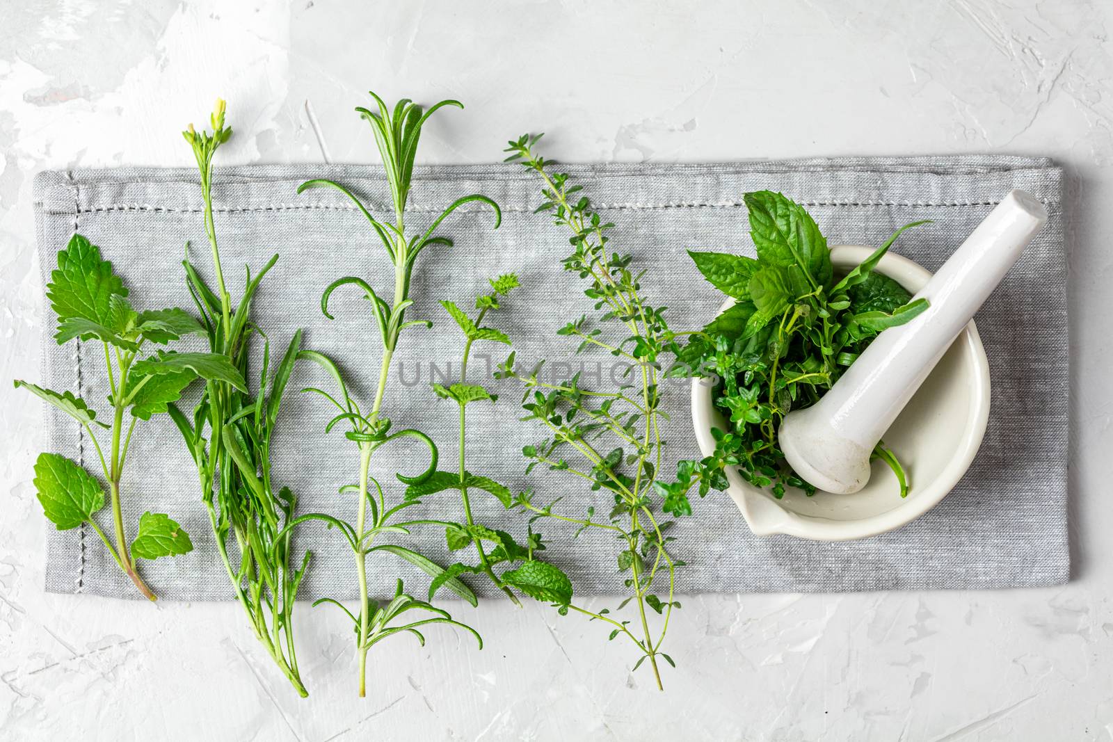 Mortar with herbs and spices. Fresh herbs selection included rosemary, thyme, mint, lemon balm, parsley and arugula. Overhead view, copy space.