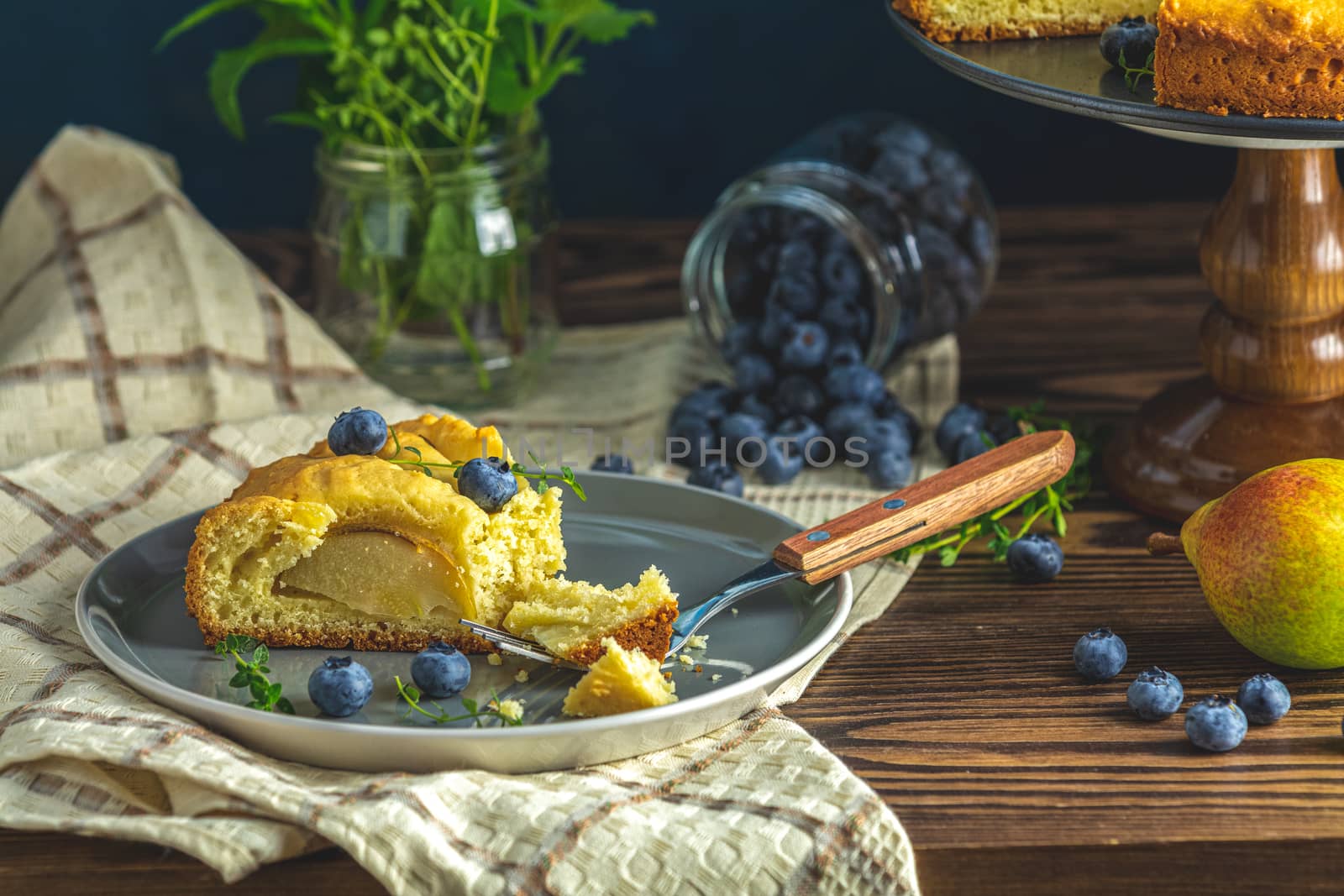 Delicious dessert blueberry tart with fresh berries and pears, sweet tasty cheesecake, berry pie. French cuisine Artistic Still Life in the style of Dutch painting. Copy space for you text