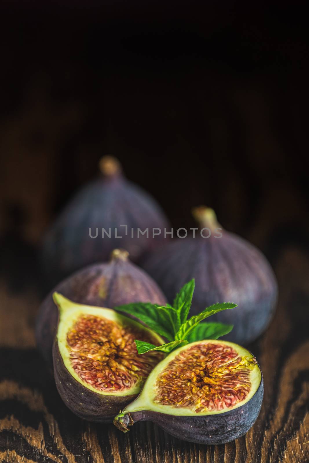 Ripe Fig Fruits on old wooden background. Paleo diet, still life with copy space. Shallow depth of the field.