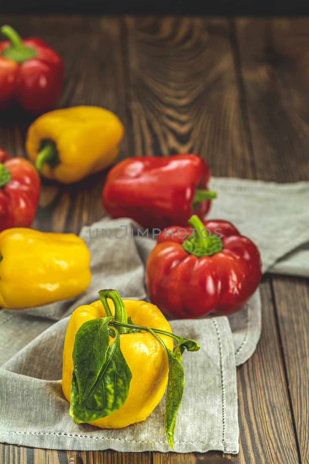 Ripe organic fresh sweet red and yellow pepper on dark wooden table. Selection of healthy food for heart, life concept