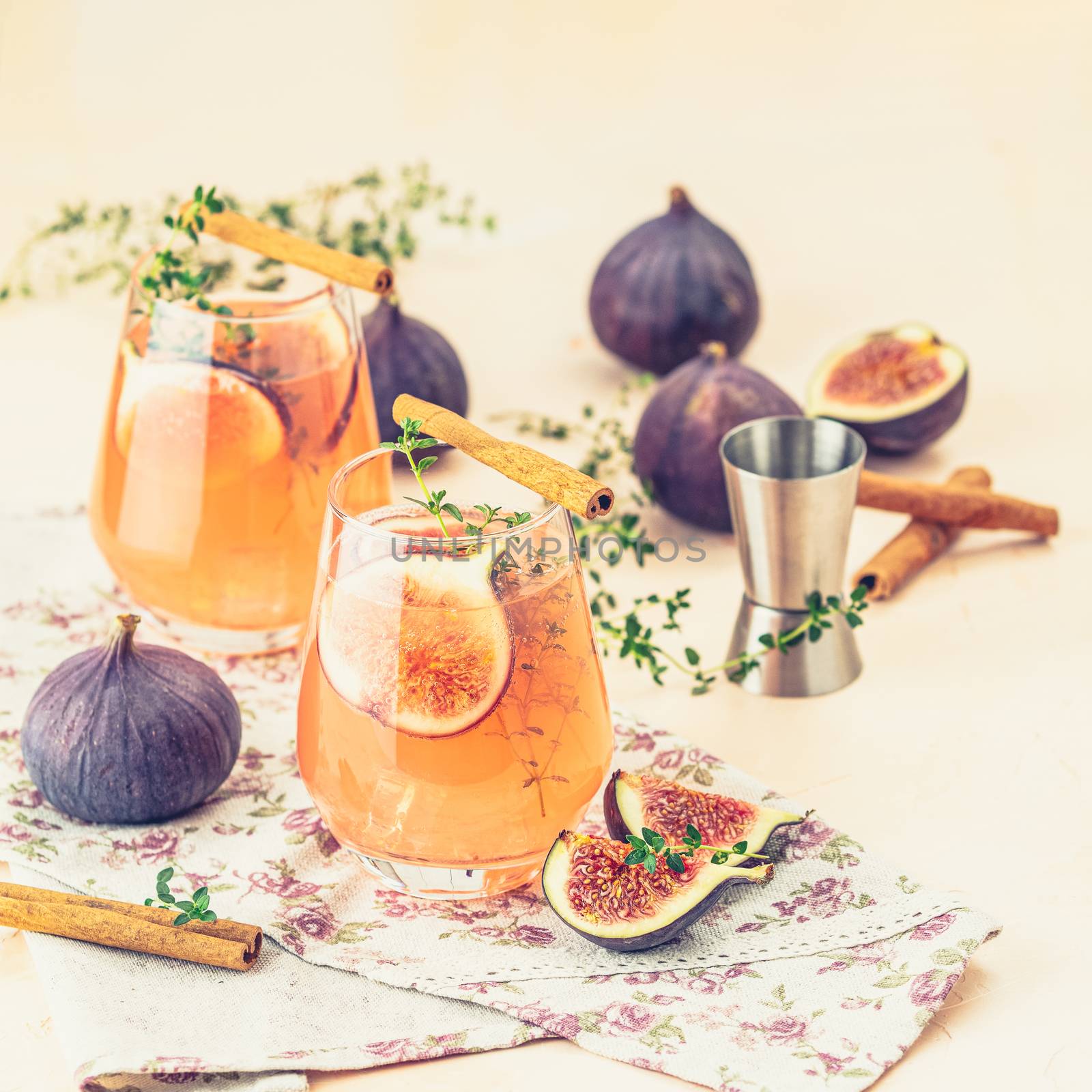 Pink cocktail with fig, thyme and ice in glass on pink concrete  by ArtSvitlyna