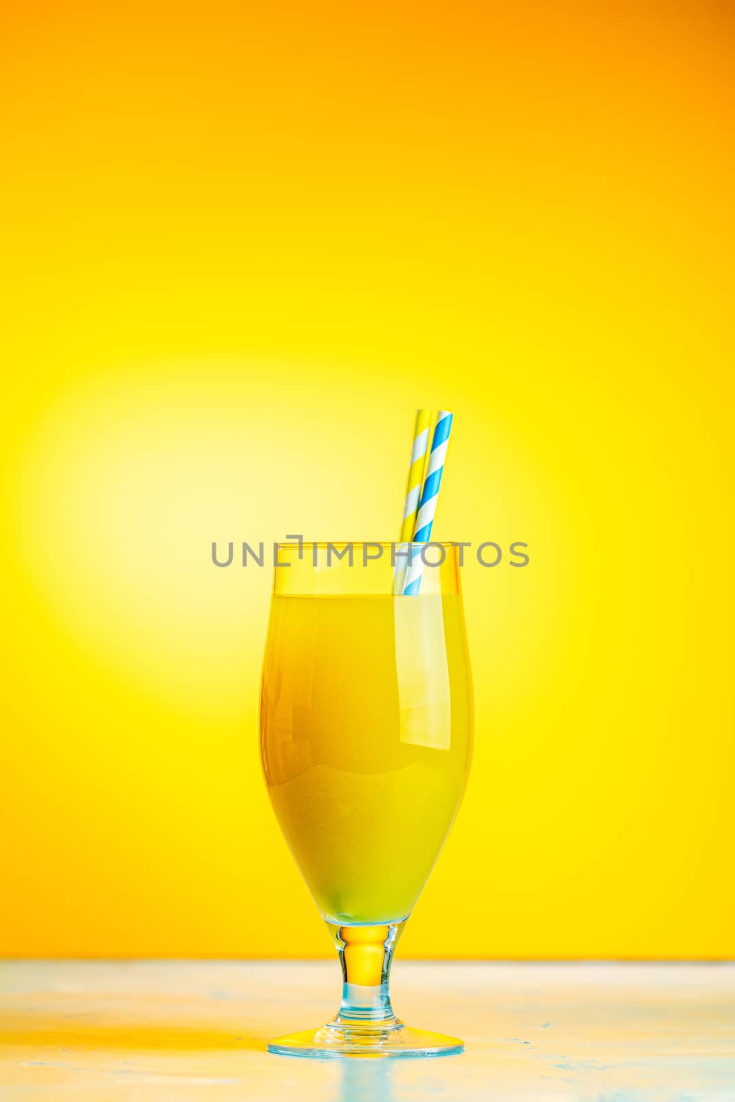 Glass of pineapple tropical fresh juice on yellow background. Summer drinks and alcoholic cocktails. 