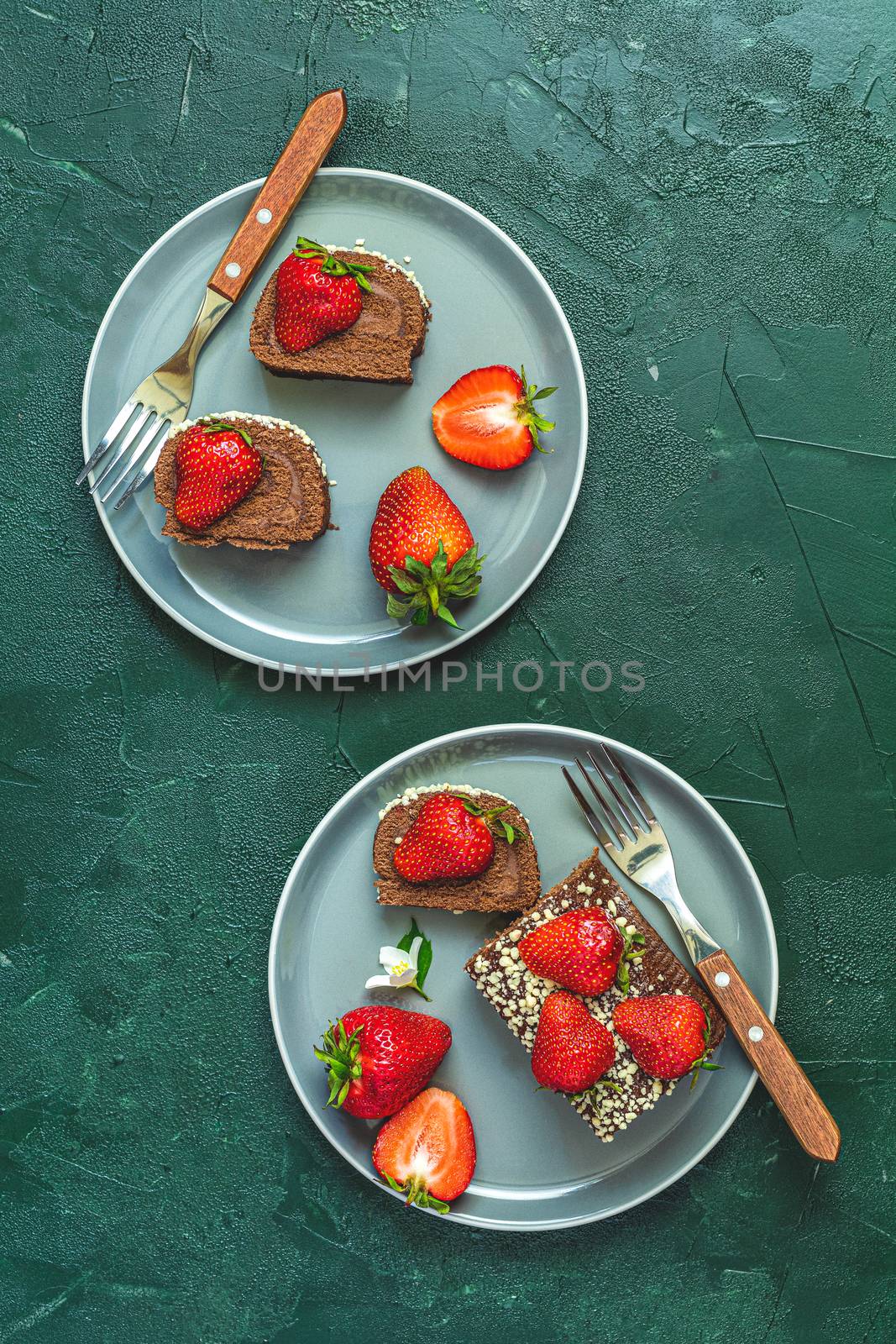 Chocolate rollcake with fresh strawberries in ceramic plate by ArtSvitlyna