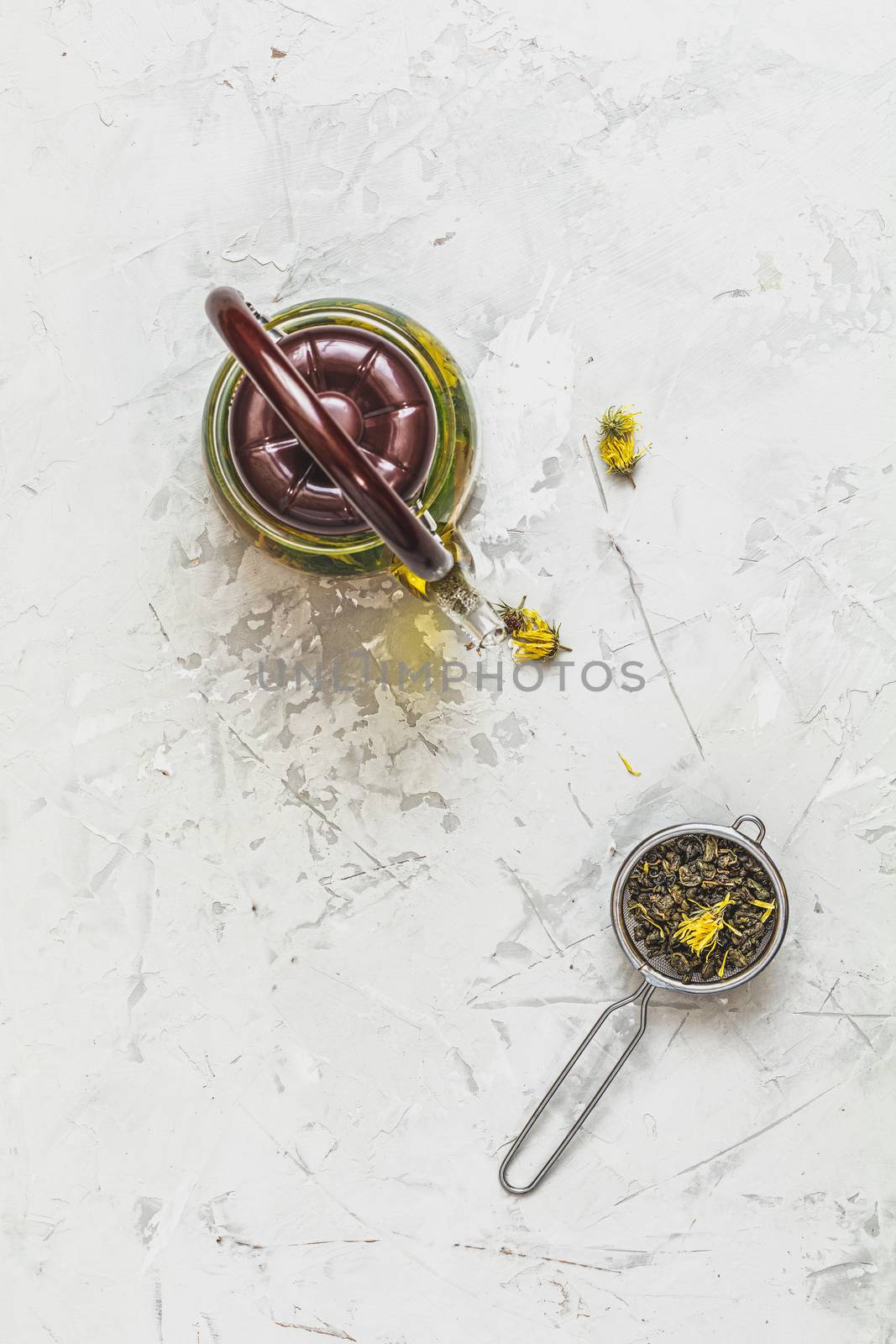 Asian tea set composition. Healthy life and relaxation concept. Glass tea pot and  green tea in strainer on light gray concrete table background. Top view, copy space for you text