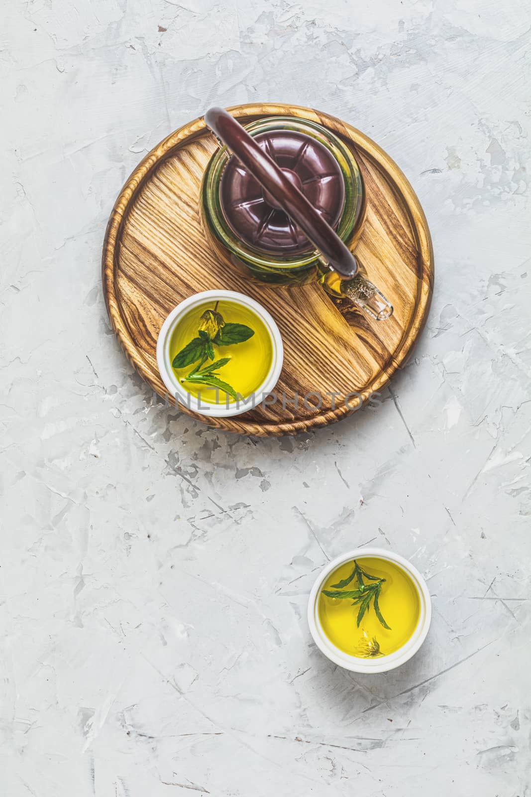 Asian tea set composition. Healthy life and relaxation concept. Glass tea pot and ceramic pot on light gray concrete table background. Top view, copy space for you text