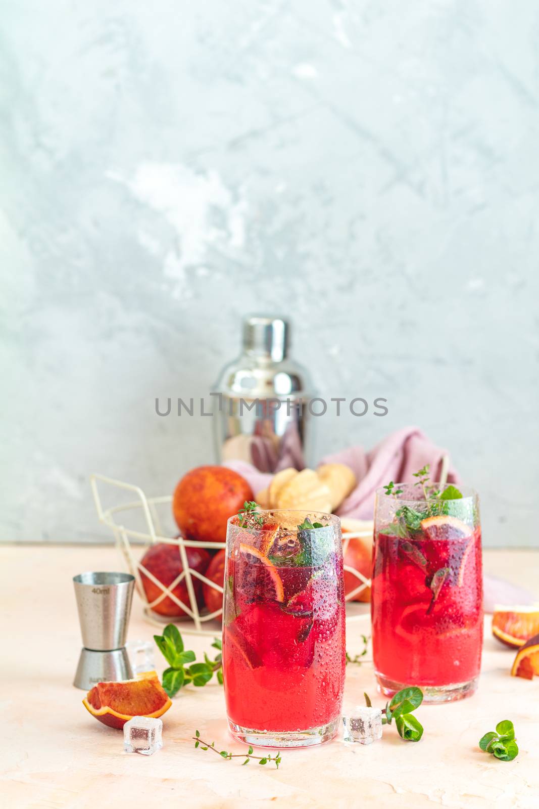 Cocktail bloody orange margarita in highball glass. Refreshing summer drinks. Cocktail blood orange margarita, in glasses on a pink concrete table surface with a garnish of orange. Copy space.