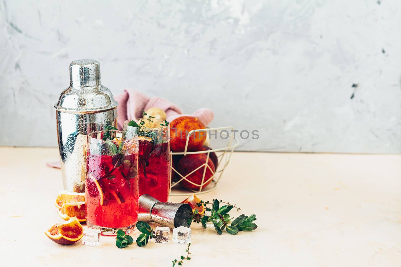 Cocktail bloody orange margarita in highball glass. Refreshing summer drinks. Cocktail blood orange margarita, in glasses on a pink concrete table surface with a garnish of orange. Copy space