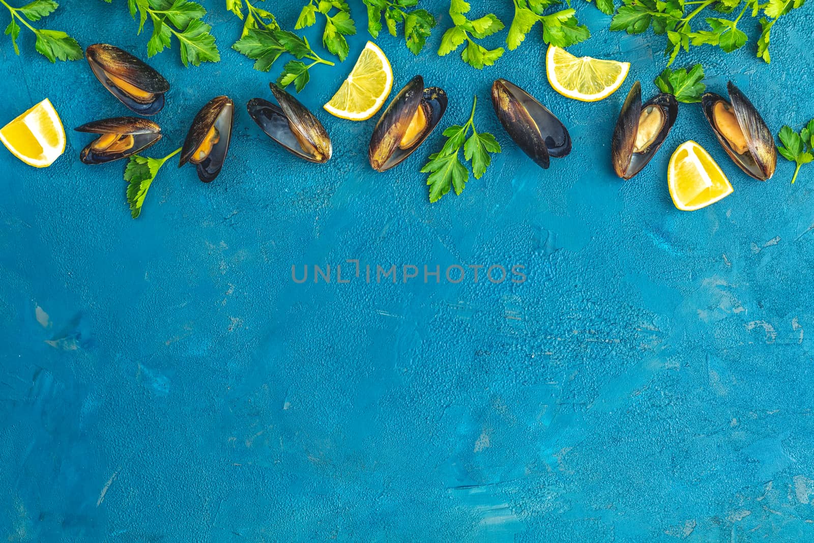 Seafood mussels with lemon and parsley on dark blue concrete table surface, top view, copy space for you text. Food background