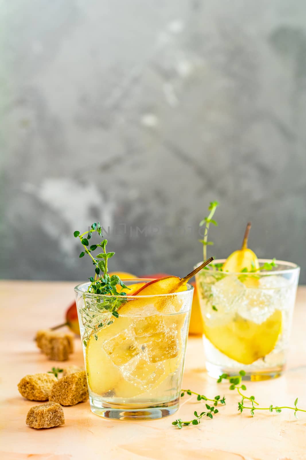 Cold pear white tea with thyme on the wooden background. Summer drinks, thyme pear cocktails. Selective focus, space for text