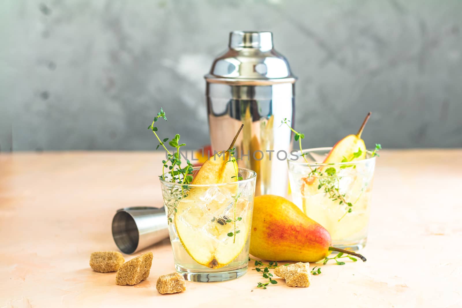 Cold pear white tea with thyme on the wooden background. Festive summer drinks, pear thyme cocktail. Selective focus, space for text