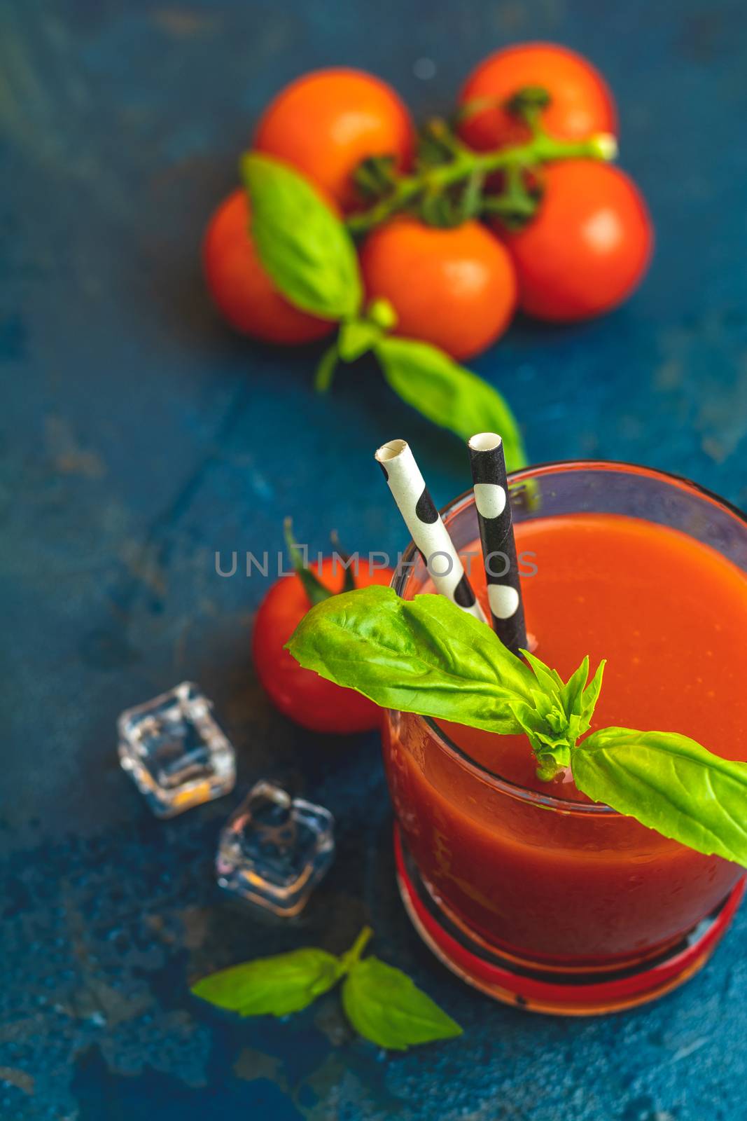 Delicious tomato bloody mary cocktail on dark blue concrete tabl by ArtSvitlyna