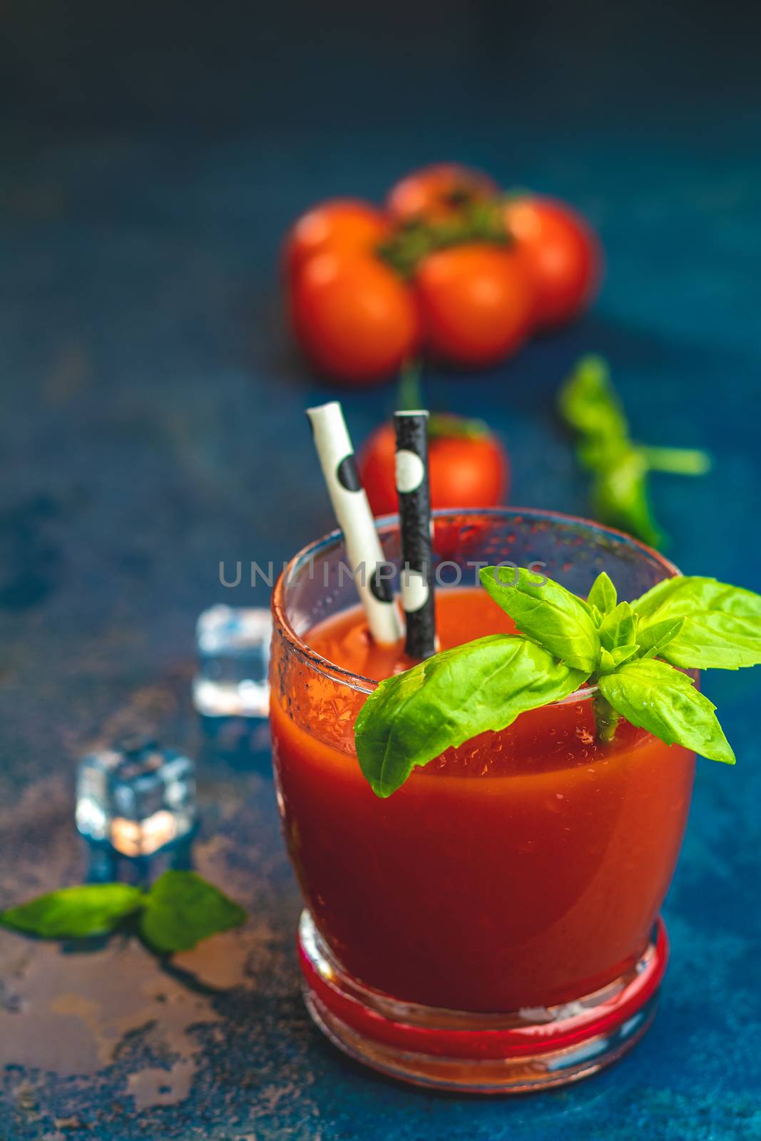 Delicious tomato bloody mary cocktail on dark blue concrete tabl by ArtSvitlyna