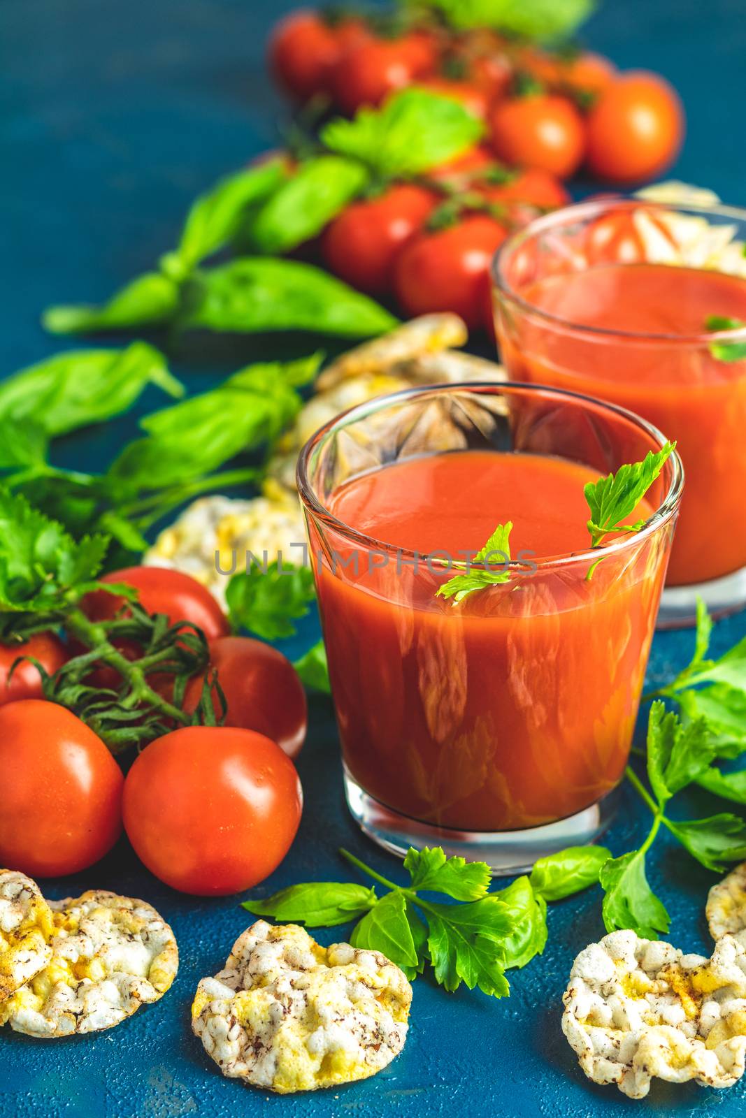 Red cocktail with tomato juice between tomatoes, basil, parsley  by ArtSvitlyna
